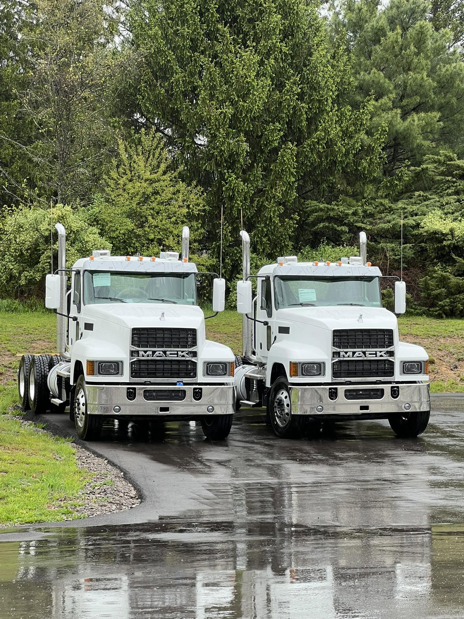 Two white Mack tractors parked together